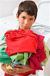 Young Boy Holding A Pile Of Laundry