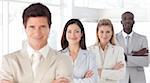 Young Business man with arms folded in front of Business Team