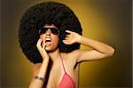 Beautiful woman with huge afro haircut on yellow