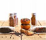 Spice glass containers on old wood table with white background