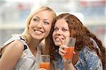 Two young women in a cafe look in one side