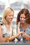 A girl-friend shows a ring a girl-friend in a cafe