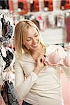 The smiling blonde considers a brassiere in shop