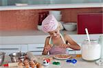 Pretty blond little girl baking in the kitchen