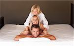 Young happy family lying on a bed