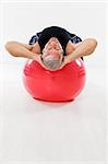 senior man working out on fitness ball and looking at camera. Copy space