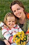 Portrait of happy woman and little girl with spring flowers