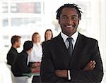 Senior business leader standing and smiling in front of his team