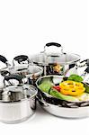 Stainless steel pots and pans isolated on white background with vegetables