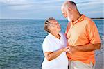 Vacationing senior couple gets romantic at the beach.