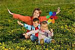 Woman with kids having fun on the spring flower field