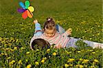 Kids having fun wrestling on the flower field in springtime