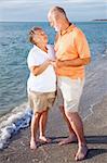 Romantic senior couple on a seaside vacation at the beach.