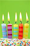 Five birthday candles on green background