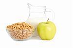 A bowl of cornflakes, fresh apple and milk pitcher on white background