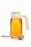 Honey pitcher and wooden drizzler, reflected on white background. Focus at front and shallow depth of field