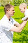 Cheerful dad and baby playing in the park