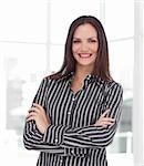 Attractive young businesswoman with folded arms smiling at the camera