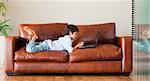 Young kid playing with a laptop on the sofa