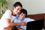 Happy mother and son playing with a laptop