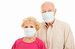 Worried senior couple wearing surgical masks to protect against an epidemic.  Isolated.