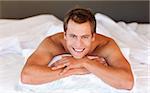 Attractive young man smiling on bed