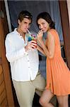 A young couple standing outside room with cocktails