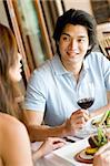 A young man enjoying wine with his meal