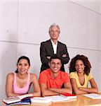 Group of happy students studying with lecturer