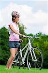 Pretty girl standing with a bicycle