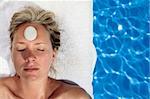 Woman at a spa with white stone on her forehead