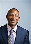 Attractive African American headshot dressed in a suit and tie, facing the camera. vertical