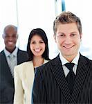 Smiling businessman in front of his team in office