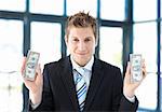Attractive businessman holding dollars in office
