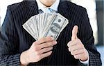 Attractive businessman showing dollars with thumbs up