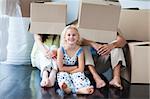 Parents and daughter playing with boxes after moving house