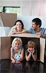 Happy family playing with boxes after moving house