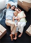 Parents and daughter sleeping on the floor of their new house