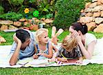 Happy family drawing together in a park