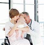 Mother with her newborn baby and doctor in hospital