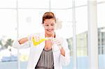 Smiling female scientist examinig a test-tube in a laboratory