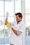 Young smiling scientist examining a chemical test-tube