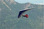 man doing hang-gliding and landing with brake parachute. World air games in Avigliana, Turin, Italy