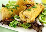 Vegetarian baked corn rolls dripping with parsley butter on a bed of mixed lettuce.