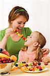 Les filles s'amusant manger des tranches de fruits à un bâton - notion de collation santé