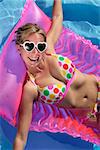 Laughing woman with sunglasses and inflatable toy