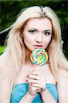 Beauty Woman With Lollipop On The Nature Background