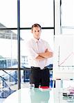 Attractive confident businessman with folded arms in a presentation