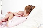 Woman kissing her newborn baby in hospital