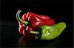 Red and green pepper over black background
